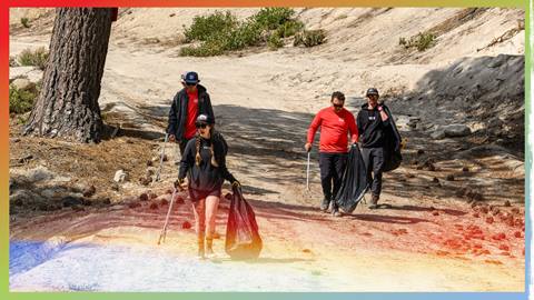 A group of four BIg Bear Mountain Resort employees walking a dirt trail at Snow Valley during summer Trash Clean Up 2024