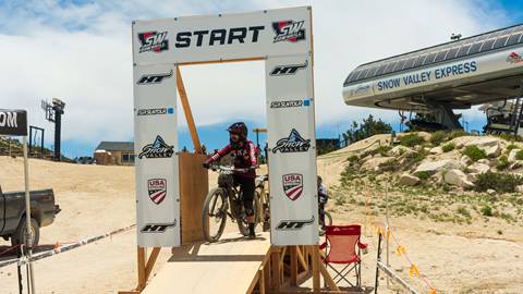 The starting line for the Southwest Downhill mountain bike race event at Snow Valley with a rider on their bike ready to hit the trail.