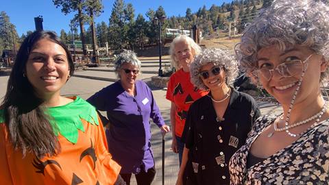 Five Big Bear Mountain Resort employees dressed up in costumes, three in fashionably older adults and two as pumpkins, during Halloween.