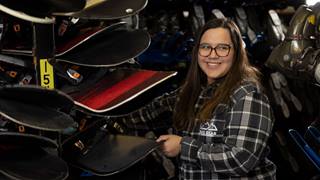 female employee working in the bear mountain rental shop with snowboards