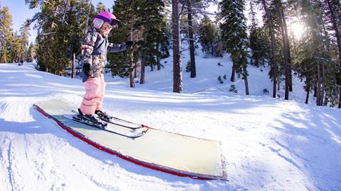 Young skier on a box feature at bear mountain the winter time