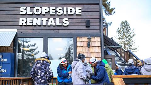 Snow Summit's Slopeside Rentals with a group of alpine enthusiasts in winter clothing waiting in line to pick up their rental equipment