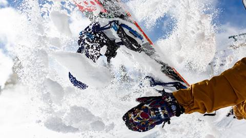 Snowboarder throwing fresh snow