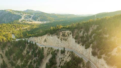 A summertime drone image of the forestry along highway 330 with Snow Valley in the background.